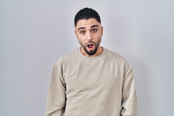 Fototapeta premium Young handsome man standing over isolated background in shock face, looking skeptical and sarcastic, surprised with open mouth