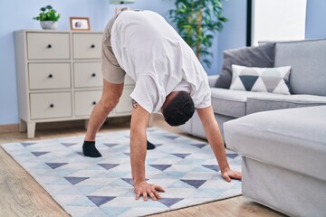 Young arab man stretching at home