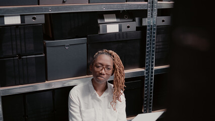Woman officer reading witness statements in incident room, examining private records and law...