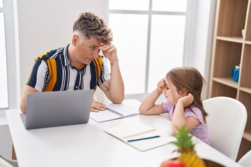 Father and daughter father and daughter stressed using laptop studying at home