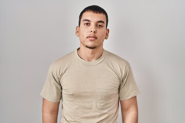 Young arab man wearing casual t shirt relaxed with serious expression on face. simple and natural looking at the camera.