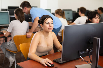 Fototapeta na wymiar Portrait of young female student studying in university computer class