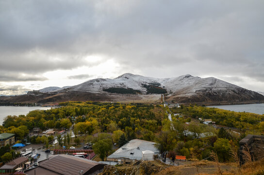 View of snowy hills and city on the peninsula of the lake Sevan from Sevanavank monastery, Armenia