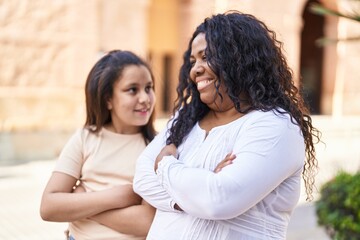 Fototapeta premium Mother and daughter smiling confident standing with arms crossed gesture at street