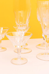 Vintage crystal glasses in front of yellow background.