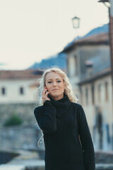 Fototapeta premium Curly blonde tourist at phone, perfect makeup