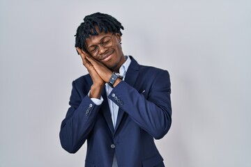 Young african man with dreadlocks wearing business jacket over white background sleeping tired dreaming and posing with hands together while smiling with closed eyes.