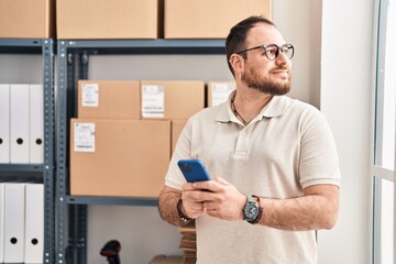 Young hispanic man e-commerce business worker using smartphone at office