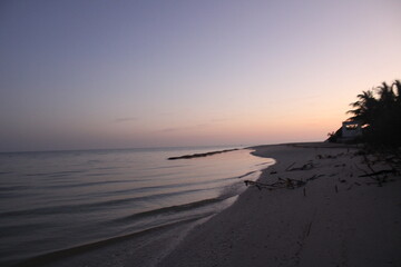 Playa tranquila al atardecer con oleaje ligero
