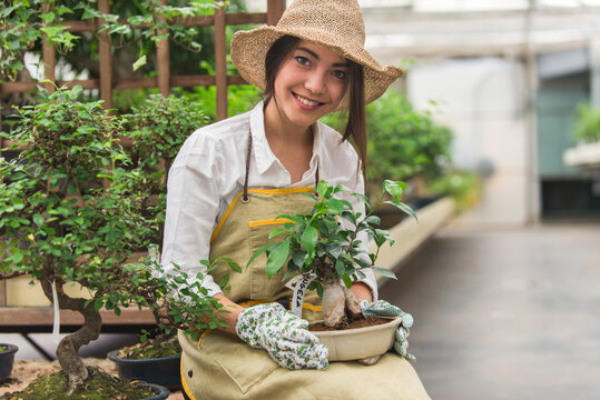 Beautiful woman working in a greenhouse - Powered by Adobe