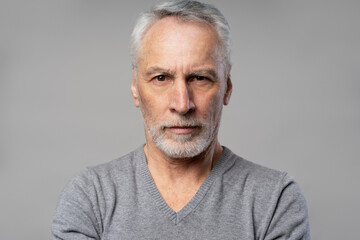Headshot of confident successful serious senior man 60 years old, retired pensioner isolated on grey
