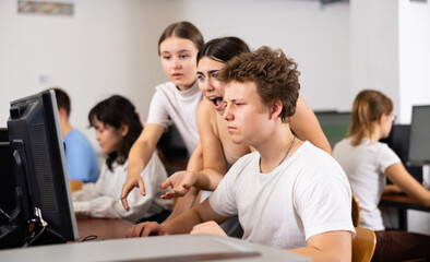 Obraz premium Teenage boys and girls using computers in IT room
