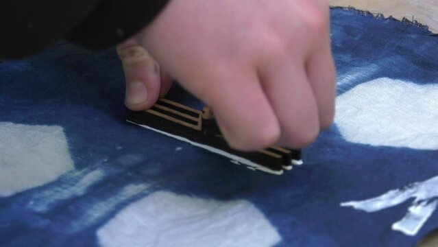 Paint being applied to material using a stamp