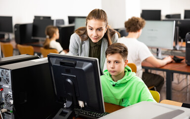 Fototapeta premium Teacher together with students conduct a lesson on computer education