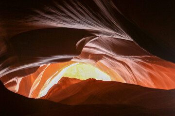 The light shines through the sandstone giving the appearance of a golden evil eye at the Upper Antelope Canyon in Page Arizona