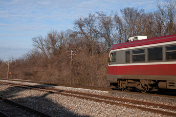Fototapeta na wymiar DMU Diesel unit from Serbian railways,passing the city of Banatsko Novo Selo on its way to Vrsac on a rural railway line, a small train route in the Serbian countryside.