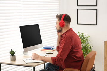 Man in headphones studying on computer at home. Online translation course