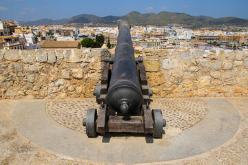 Fototapeta na wymiar Old cannon on the fortification walls of Eivissa, the capital city of Ibiza in the Balearic Islands, Spain - Medieval citadel in the Mediterranean Sea
