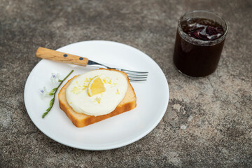 homemade lemon cake on dish with iced coffee in glass for eating in relaxing time