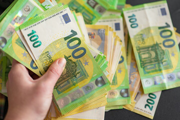 one hundred euro banknotes in hand close-up.European Union money. Earnings and spending in the Eurozone.Salary, benefits and pensions in Europe.