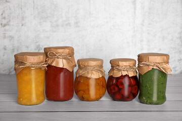 Jars with canned fruit jams on wooden table