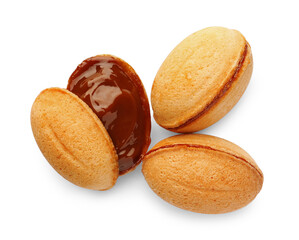 Delicious nut shaped cookies with boiled condensed milk on white background, top view