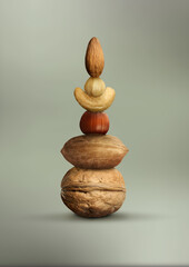 Stacked different nuts on grey gradient background
