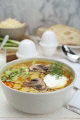Delicious sauerkraut soup with mushrooms, dill and sour cream served on white table