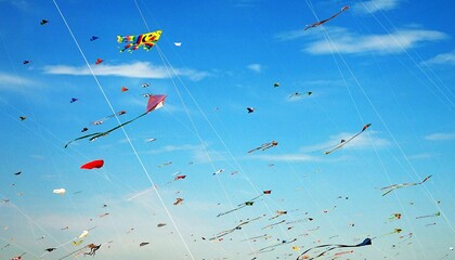 Image of a gathering of many colorful kites on sunny day with blue sky
