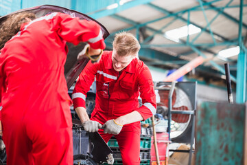 Mechanics in uniform are working in auto service, Technician checking modern car at garage, Car repair and maintenance concepts