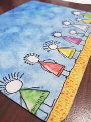 A mouse pad with a doodle depicting a group of children standing on a brown ground