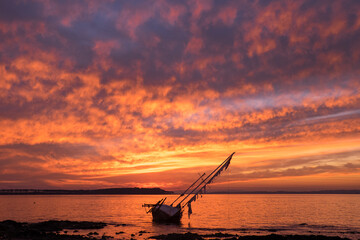 Old sailboat stranded in front of Gorriti Island, during sunset
