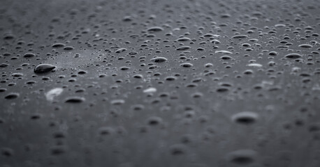 Background texture of water drop on black surfaces, design for skin, wallpaper or elegant backdrop.