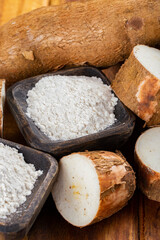 Fototapeta na wymiar pile of cassava, cassava and cassava flour on a background of rustic wood (Manihot esculenta)