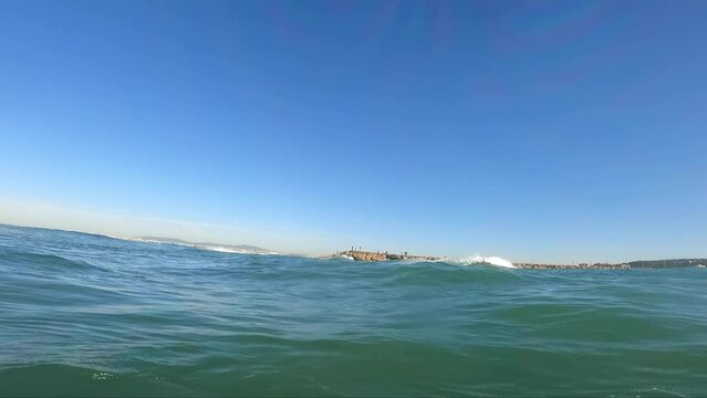 Beautiful Beach Landscape Rock Path Ocean. Wide shot of a long ocean walkway with people on a bright sunny day