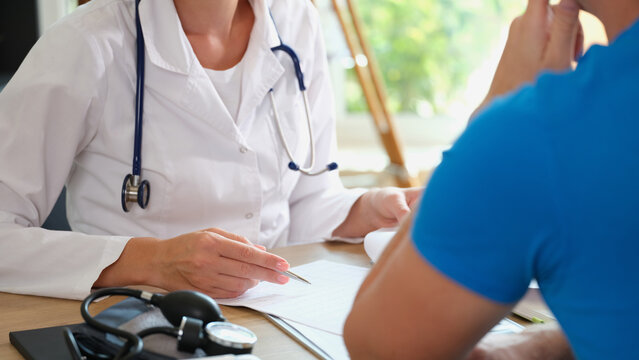 Doctor prescribes medicaments for male patient in office