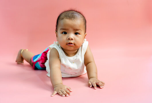 Asian baby 6 month old on pink background
