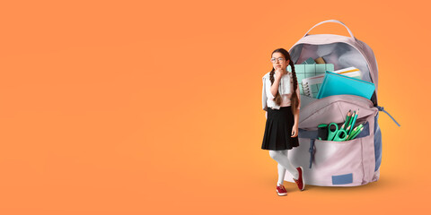 Cute little girl and big schoolbag on orange background with space for text