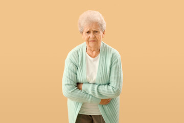 Senior woman with appendicitis on beige background