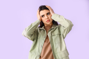 Troubled young woman on lilac background