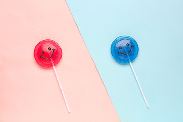 Red and blue lollipops with smiles on colorful background