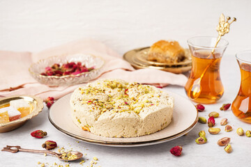 Plate of tasty Tahini halva with pistachios on light background