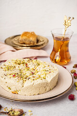 Plate of tasty Tahini halva with pistachios on light background