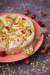 Plate of tasty Tahini halva with pistachios on grunge background, closeup