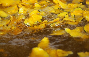 Fried Pumpkin Snacks.Pumpkin slice chips in wooden plate.Closeup topview of fried pumpkin crisp.
