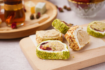 Wooden board with tasty Turkish Delight on light background, closeup