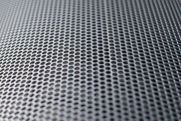 The camera focuses on a narrow section of a steel panel that has an endlessly repeating pattern of circles. 