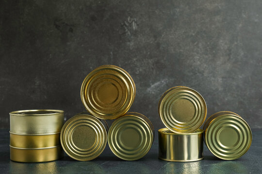 Assortment of tin cans with fish on dark table