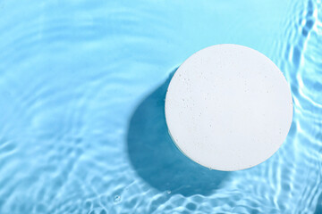 Decorative plaster podium in water on blue background