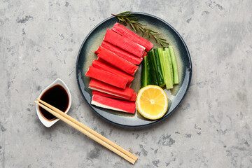 Plate with tasty crab sticks and sauce on grunge background © Pixel-Shot